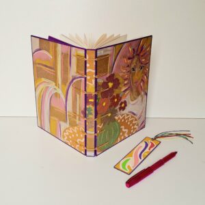 Carnet SUZANA ouvert avec un stylo rose et un marque-page en bois