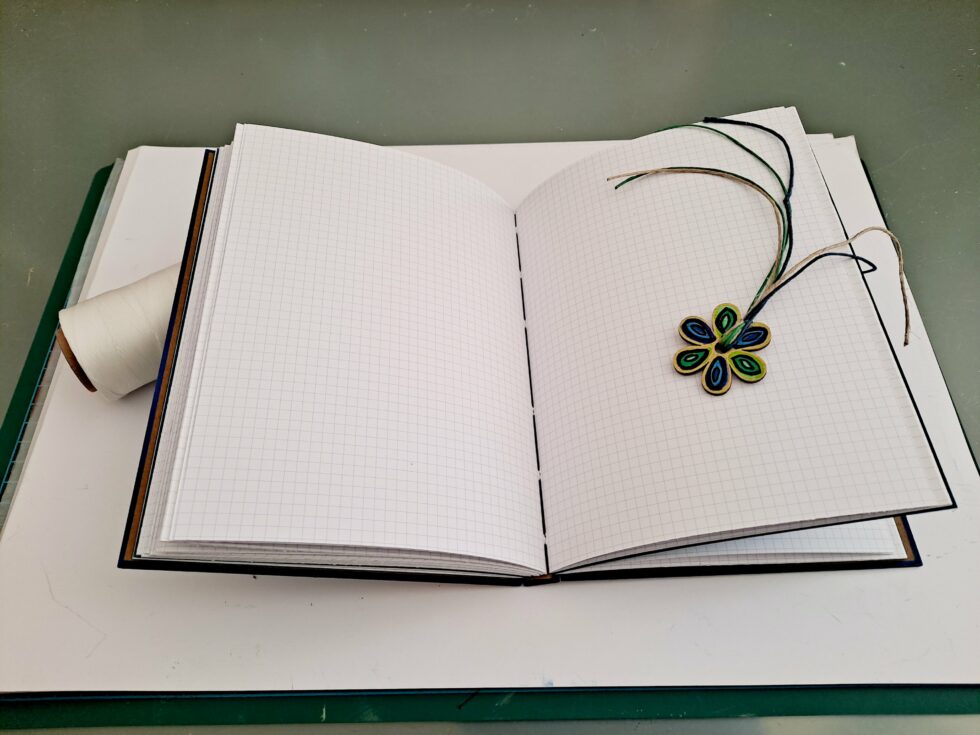 Carnet HOULE vue intérieur pages avec stylo en bois et marque page fleur.