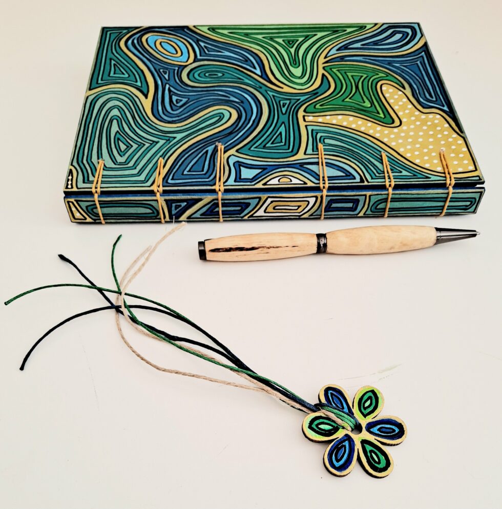 Carnet HOULE vue dos reliure avec stylo en bois et marque page fleur.