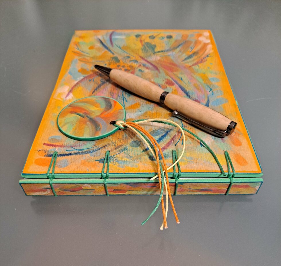 Carnet ÉTÉ INDIEN, vue recto et dos avec reliure or avec marque-pages en bois peint à la main et stylo.