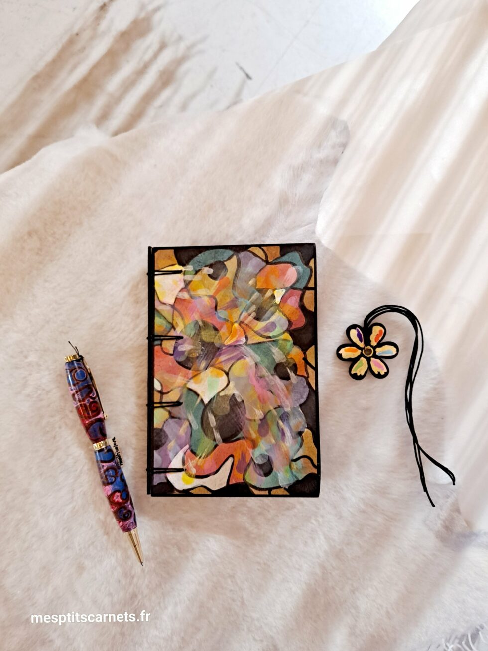 Carnet MAG, vue recto face couverture avec marque-pages en bois peint et stylo.