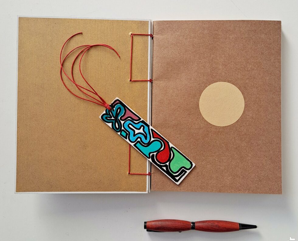 Carnet CORAIL vue intérieur sur page de garde avec marque-pages en bois et stylo en bois.