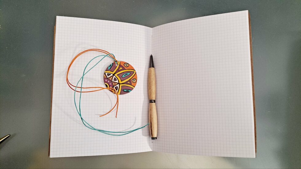 Carnet Semainier PHOENIX vue ouverte à plat intérieur pages avec marque-pages et stylo en bois.